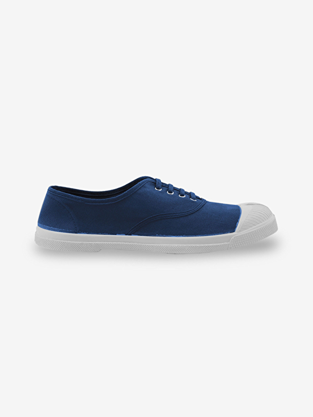 hombre con cordones de tenis en el extranjero