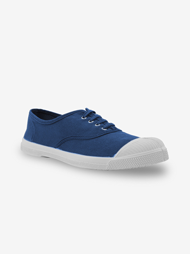 hombre con cordones de tenis en el extranjero