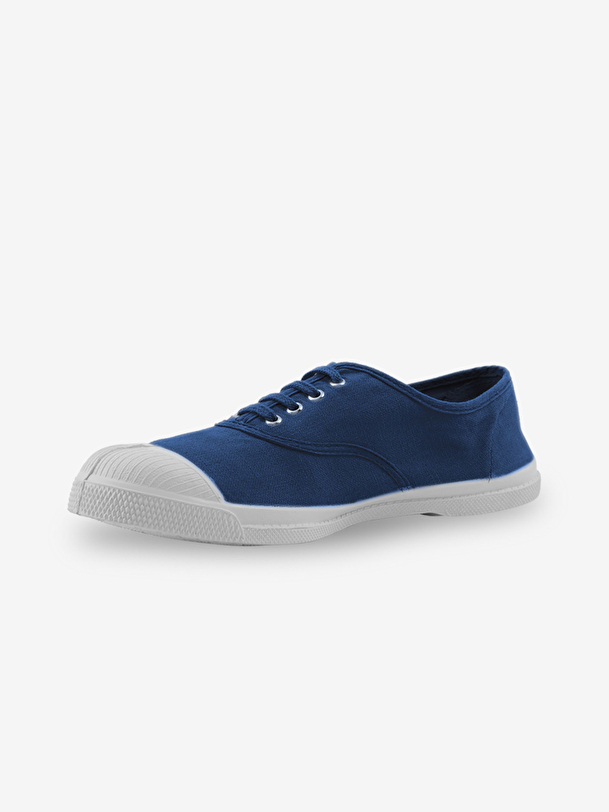 hombre con cordones de tenis en el extranjero